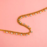 Collar Dorado de Acero de Titanio - Luminoso fondo rosa