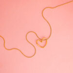 Collar de Acero de Titanio - Contorno Corazón fondo rosa