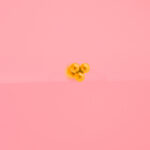 Piercing Dorado de Acero Inoxidable de Tres Bolitas fondo rosa