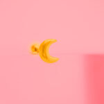 Piercing dorado de acero inoxidable de luna fondo rosa