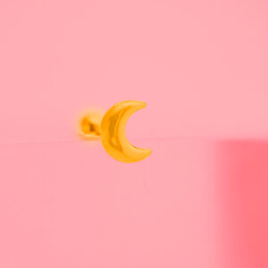 Piercing dorado de acero inoxidable de luna fondo rosa